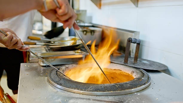 Chef cooking in the tandoor oven at Indian Royal Spicy